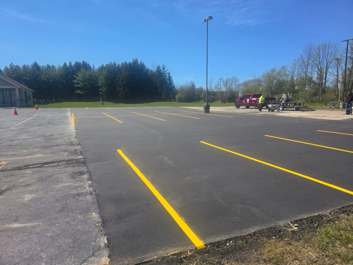 a sealed commercial lot with crisp fresh yellow striping and trees behind by Draki Enterprises in Wisconsin