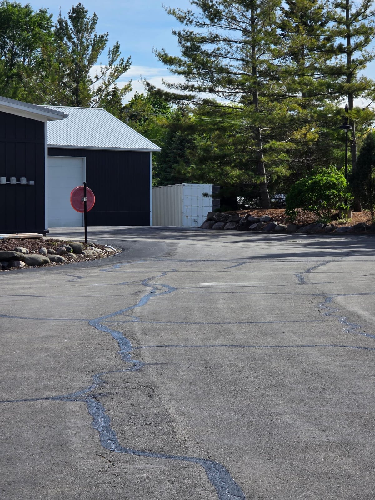 a dark commercial building with a freshly sealed black parking lot and a stop sign by Draki Enterprises in Wisconsin