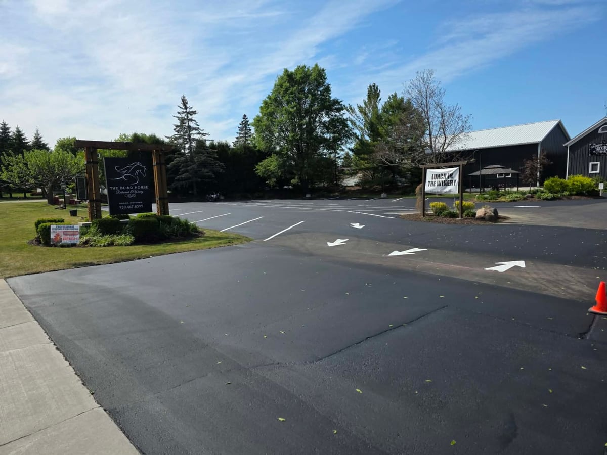 a sealed commercial lot with fresh ADA and stall striping and a monument sign by Draki Enterprises in Wisconsin