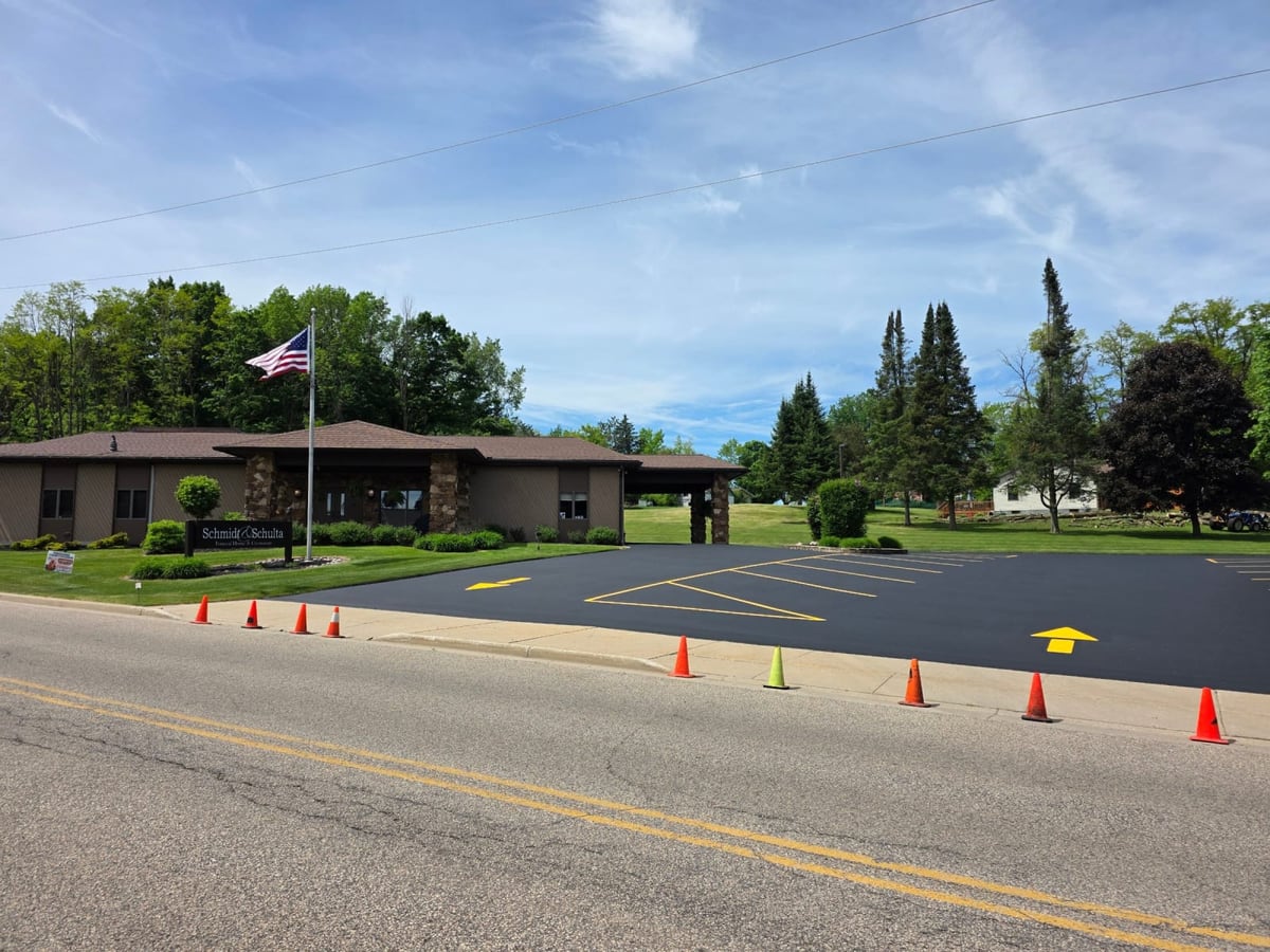 a municipal parking lot being line striped, cones set out and yellow arrows painted by Draki Enterprises in Wisconsin