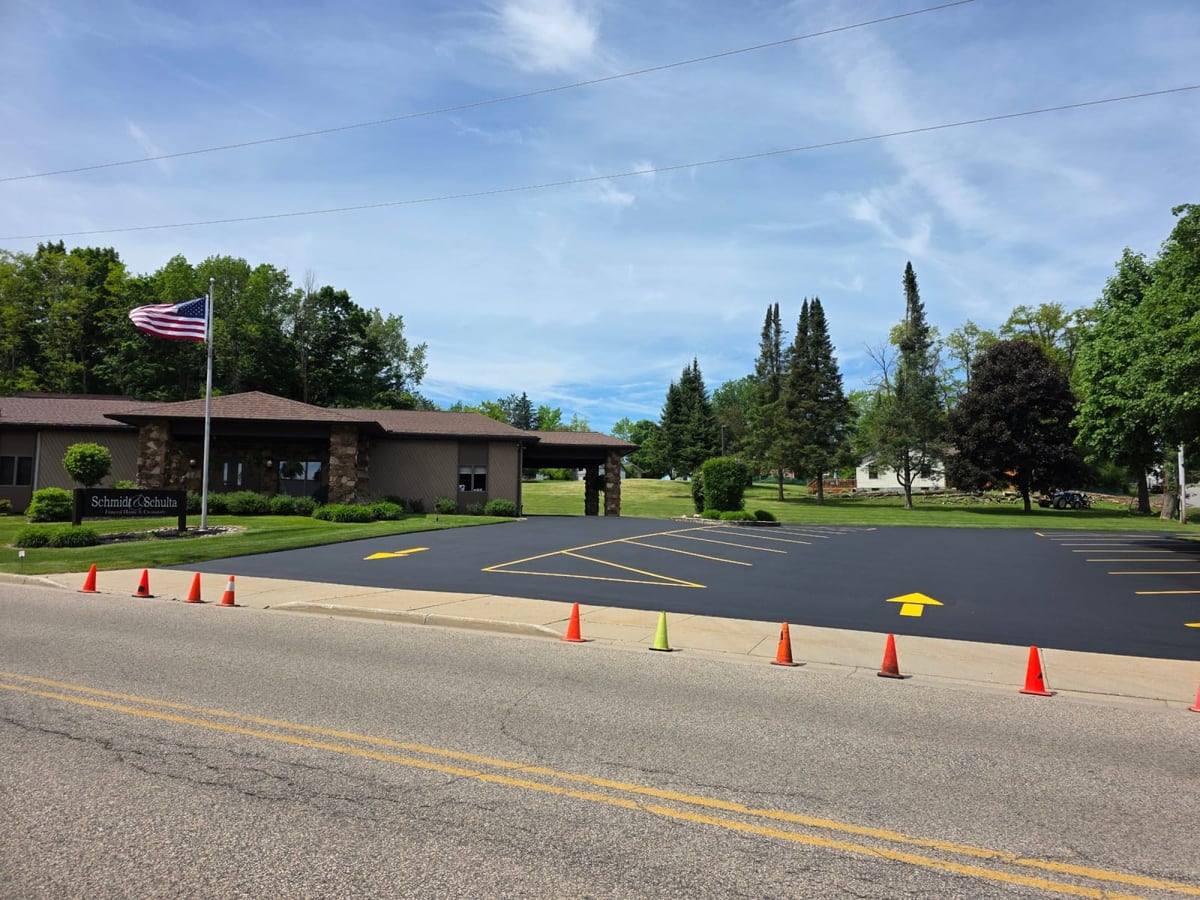 a lot laid out for striping with a row of cones and painted markings by Draki Enterprises in Wisconsin
