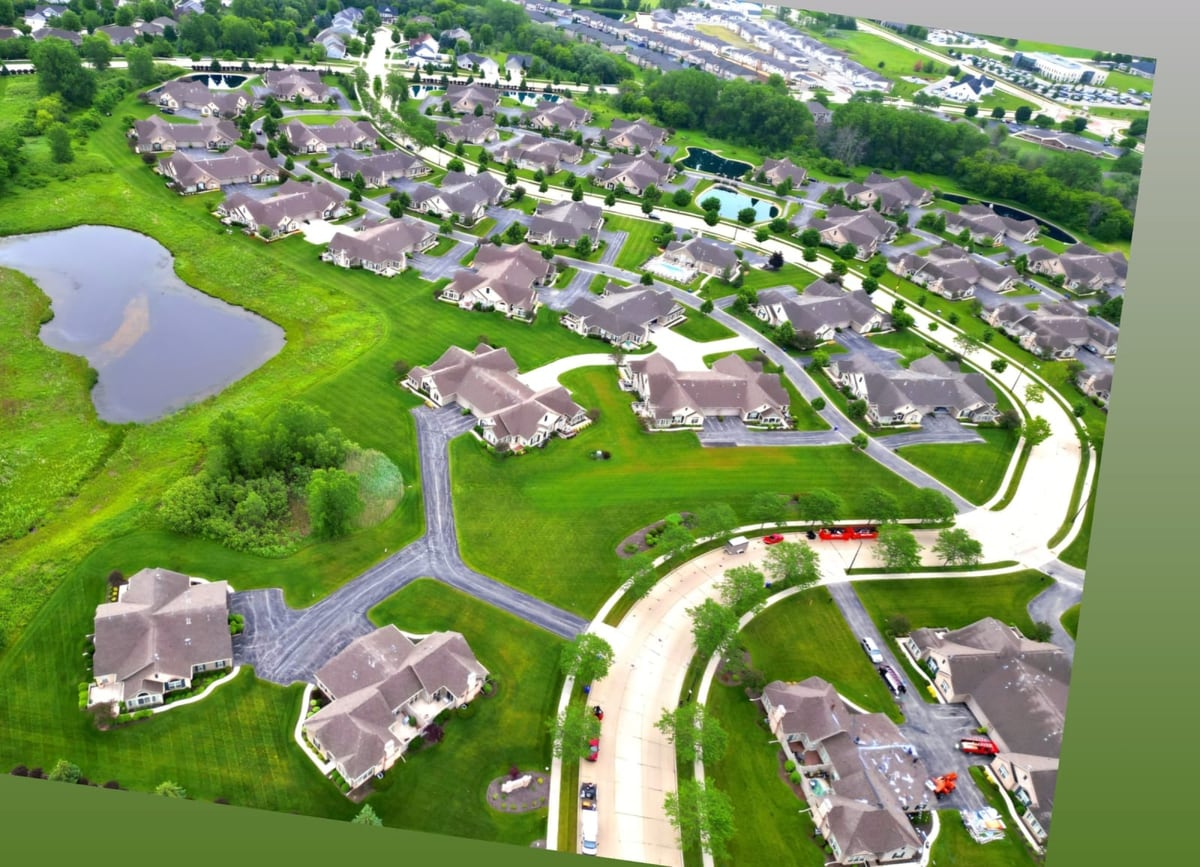 drone aerial of a residential community with freshly sealed roads winding between the homes by Draki Enterprises in Wisconsin