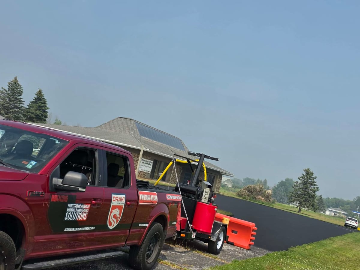 the Draki work truck with the crack seal trailer staged at an open paved site in Wisconsin