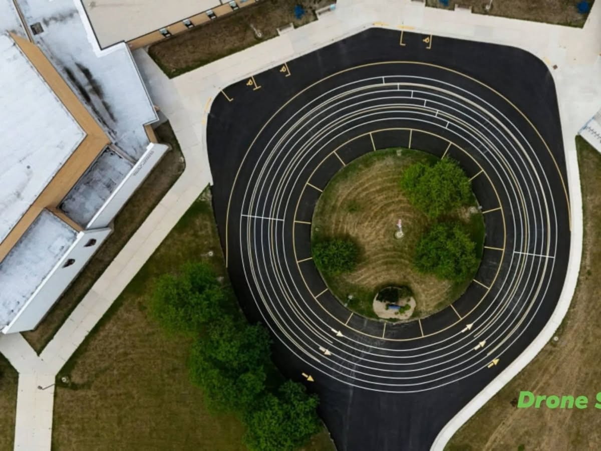 top-down drone shot of the freshly sealed and striped bus loop at Howards Grove by Draki Enterprises in Wisconsin