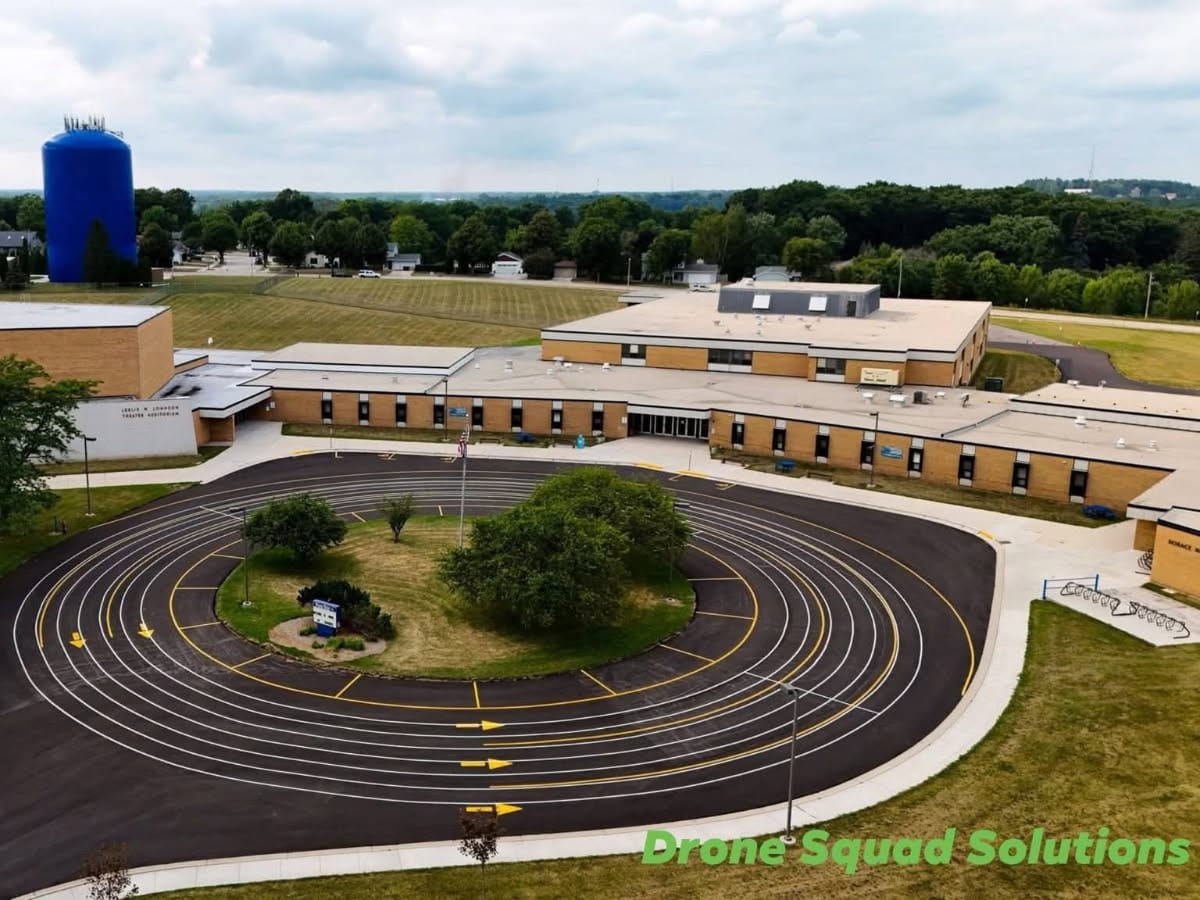 wide drone view of the Howards Grove campus with sealed lots and the striped bus loop by Draki Enterprises in Wisconsin